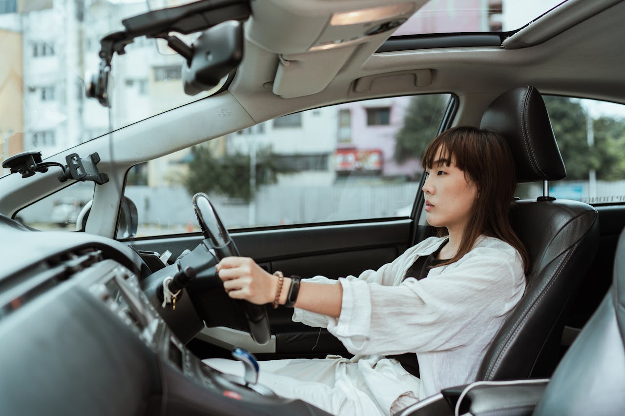 services-01 Confident young woman driving in the city, focused and pensive.