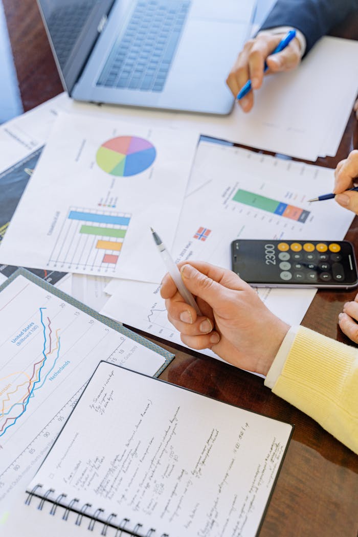 contact-img A close-up of businesspeople analyzing financial data and charts during a meeting.